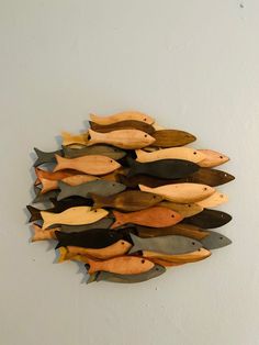 a group of wooden fish mounted to the side of a wall next to a white wall