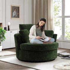 a woman sitting in a green chair reading a book