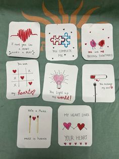 handmade valentine's day cards are displayed on a green cloth covered tablecloth