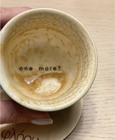 a person holding a coffee cup with the word one more written on it