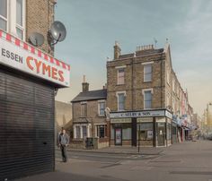 a man is walking down the street in front of some buildings and stores on a sunny day