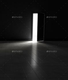 an open door in a dark room with light coming through it - stock photo - images