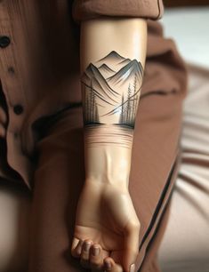 a person with a mountain tattoo on their arm