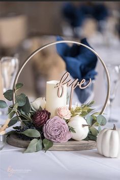 a table topped with a white candle and flowers