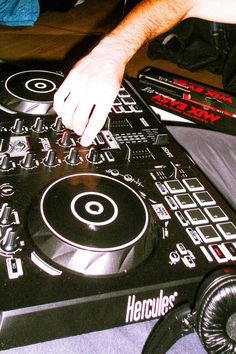 a dj playing music on his turntable with headphones around it's neck