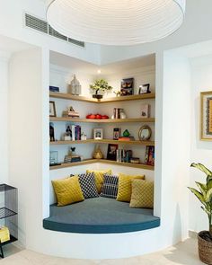 a living room filled with lots of furniture and shelves next to a potted plant