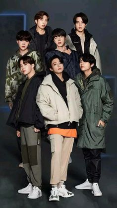 the group of young men are posing together for a photo in front of a dark background