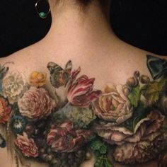 a woman's back with flowers and butterflies on it