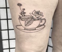 a black and white photo of a teacup with flowers on it's side