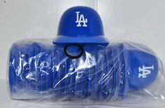 a blue plastic baseball helmet with the los angeles dodgers on it is wrapped in plastic