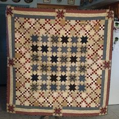 a large quilt hanging from the side of a refrigerator