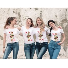 three women wearing t - shirts with flowers and hearts on them, posing in front of a stone wall