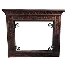 an ornate wooden frame with carvings on the top and bottom, against a white background