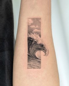 a black and white photo of a wave on the back of a woman's arm