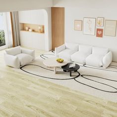 a large living room with white furniture and wood flooring, along with an ocean view