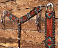 a pair of horse bridles hanging on the side of a wooden wall next to a rope