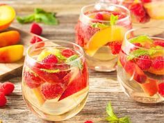 fresh fruit in wine glasses with mint and peaches on wooden table stock photo - images