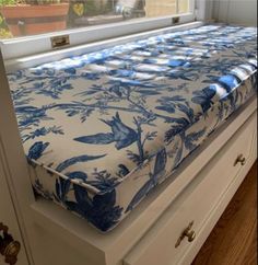 a blue and white bed sitting on top of a dresser