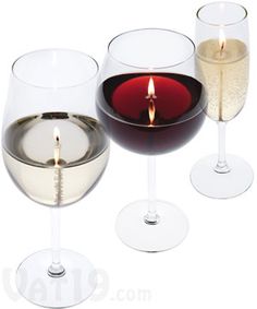 three wine glasses with candles in them