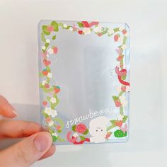 someone is holding up a small mirror with flowers on it