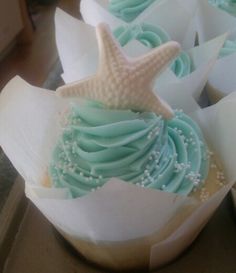 some cupcakes with blue frosting and a starfish on top