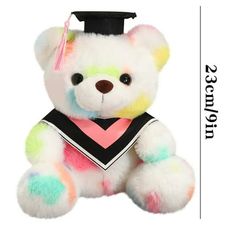 a white teddy bear wearing a graduation cap and gown