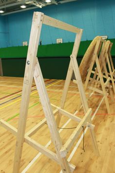 several wooden ladders are on the floor in an indoor gym with hard wood floors