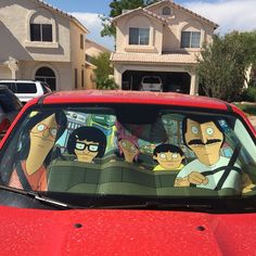 the back window of a red car with cartoon characters on it