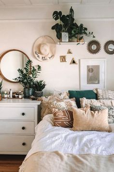 a bed room with a neatly made bed and lots of plants on the wall above it