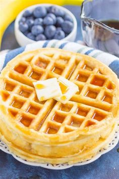 a waffle on a plate with butter and blueberries