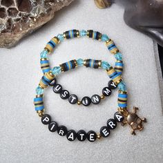 "The Just In My Pirate Era ☠️ Beaded Word Bracelet Set was made using 4mm glass seed beads, 6mm crystal bicone beads, and heishi clay beads. The words \"JUST IN MY PIRATE ERA\" are spelled out on white round letter beads in black writing. A gold tone skull and cross bones dangles from the bracelet.  Bracelets are all HANDMADE with love and care by myself, Candice Marie, and they are always limited edition and one-of-a-kind. ❤️ The bracelet is stretchy and stackable and looks great stacked with o Pirate Bracelet, Heishi Bead Bracelet, Word Bracelets, Skull And Cross Bones, Preppy Bracelets, Cross Bones, Black Writing, Word Bracelet, Letter Beads