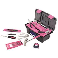 a pink tool box filled with tools on top of a white table next to other items