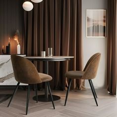 two chairs sitting at a table in front of a marble counter top and brown drapes