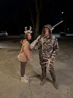 two people dressed up as deer hunters in the parking lot at night with their arms wrapped around each other