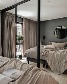 a bedroom with black walls and white flooring is pictured in this image, there are two beds that have pillows on them