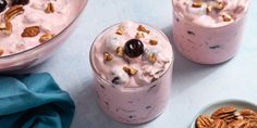 two desserts with nuts and yogurt in them on a blue tablecloth