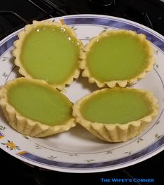 four tarts sitting on top of a white and blue plate