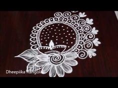 an intricate design on a wooden table with white flowers and leaves in the center,