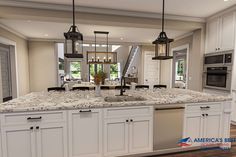 a large kitchen with white cabinets and marble counter tops