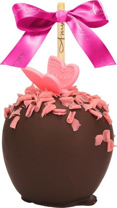 a chocolate ball with pink sprinkles and a wooden stick sticking out of it