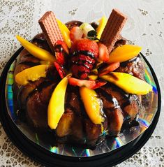 a cake decorated with fruit and ice cream on top of a tablecloth covered plate