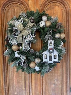 a christmas wreath hanging on a door with ornaments around it and a church in the background