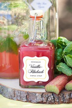 a jar filled with red liquid next to some green leaves and other vegetables on a table