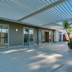 an outdoor patio with sliding glass doors and potted palm tree in the foreground