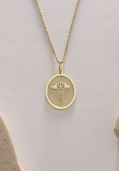 Gold Caduceus Pendant - Medical Gold Necklace ● Material of pendant: Solid Gold 14k ( REAL GOLD ) ● Metal Stamp: 14k ( REAL GOLD ) ● The pendant is available in 5 sizes: - 12x17 mm / 0,47 x 0,66 inches - 13x18 mm / 0,51 x 0,70 inches  In the photos - 14x19 mm / 0,55 x 0,74 inches  - 16x21 mm / 0,62 x 0,82 inches  - 18x24 mm / 0,70 x 0,94 inches ( In the photos the size is 13x18 mm / 0,51 x 0,70 inches ) ( Jump Ring inner diameter: 4 mm ) ● Material of chain: Solid gold 14k ( REAL GOLD ) It is thin and dainty and it is available in 4 sizes: - 40 cm / 15,75 inches ( Length ) - 45 cm / 17,72 inches ( Length ) In the photos - 50 cm / 19,68 inches ( Length ) - 55 cm / 21,65 inches ( Length ) ● Backside engraving is FREE ( Please use the personalization box for that.) ● If you want larger size, Medical Pendant, Medical Alert Necklace, Medical Alert, Gold Birthday, We Can Do It, Jump Rings, Metal Stamping, Real Gold, Necklace Gold