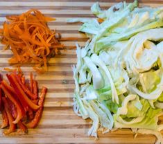 lettuce, carrots and cabbage on a cutting board next to each other