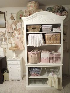 a white bookcase filled with lots of baskets