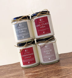 three jars of candles sitting on top of a wooden table