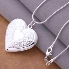 The perfect spot to keep your loved ones close. This beautiful heart shaped locket is finished in highly polished and has intricately detailed floral stamped designs along the front.The front opens on a hinge to hold photos or small momentos, a classic gift idea! Includes a smooth, 18 inch serpentine style chain. Occasions: Birthday, Holiday, Christmas, Mother's Day and Valentine's Day. Chain: 18 inch Serpentine style chain Material: Silver Plated (nickel free)brass Size: 29mm x 29mm Comes in a Gold Diamond Heart Necklace, Silver Heart Locket, Photo Locket Necklace, Heart Photo, Sterling Silver Locket, Heart Locket Necklace, Locket Pendant Necklace, Photo Locket, Silver Plated Necklace