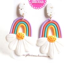 a pair of earrings with flowers and rainbows on them